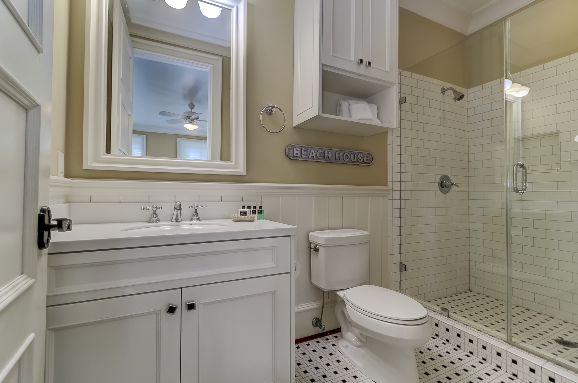Your coastal-themed bathroom awaits with crisp subway tiles, spacious glass shower, and charming beach house touches.