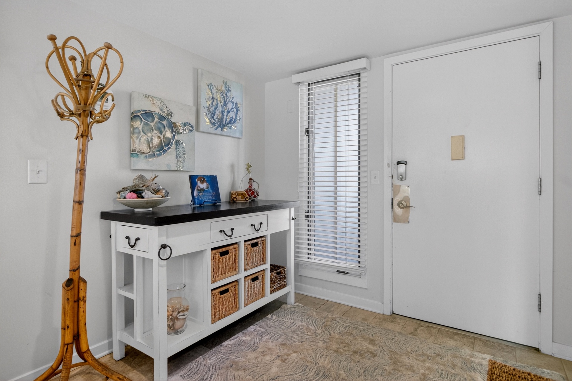 Step into your coastal retreat through this inviting entry, where beach-themed décor and thoughtful storage greet you. Natural light filters through the window, setting a relaxed, breezy tone for your stay.
