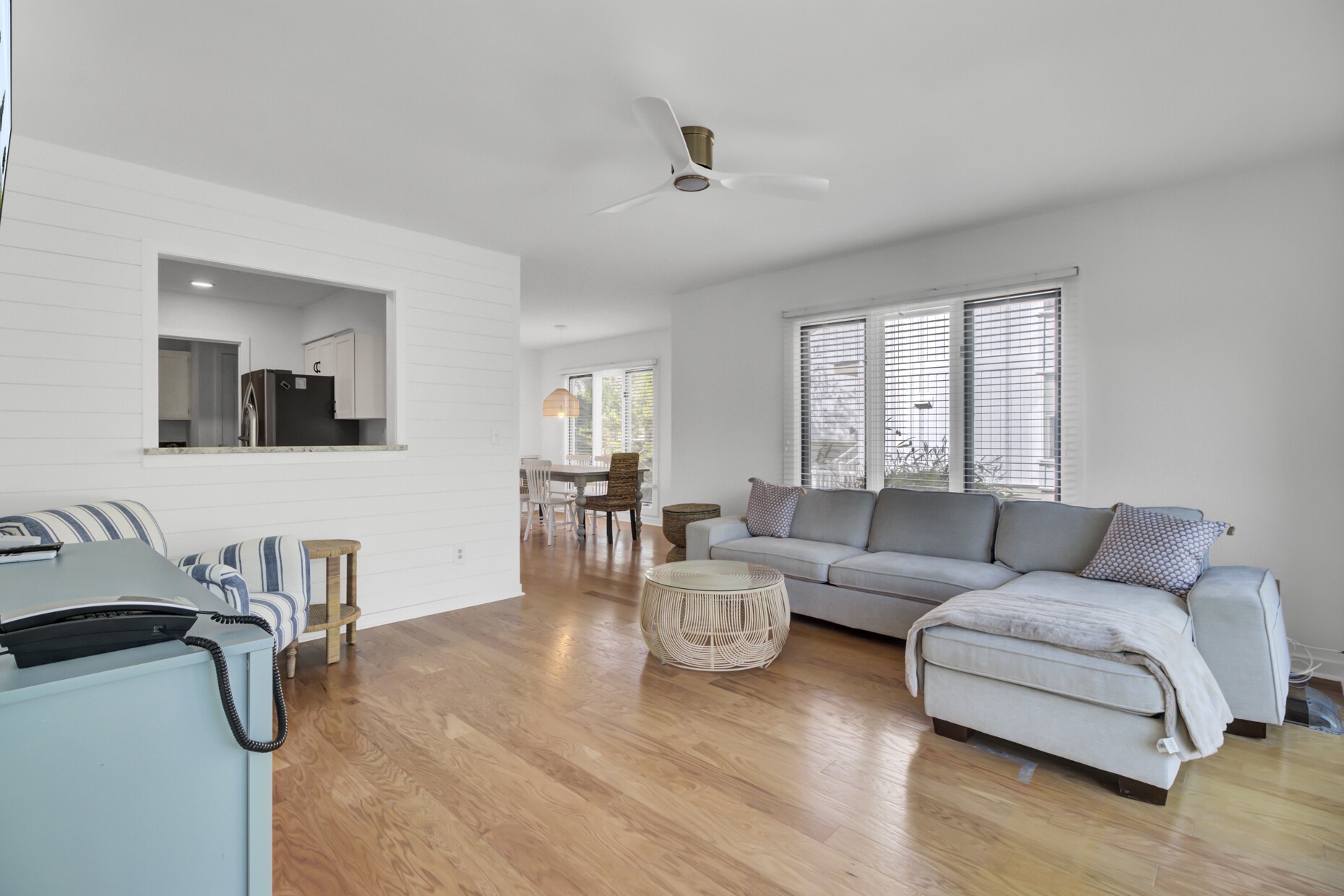 Unwind in your spacious living room featuring comfortable sectional seating, natural light streaming through large windows, and seamless flow to the modern kitchen.