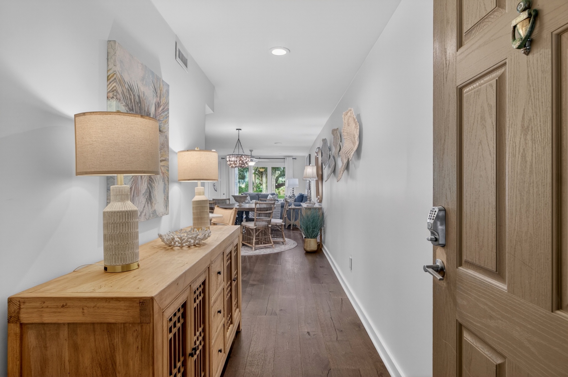 Step inside to warm wood tones and coastal-inspired décor guiding you toward a bright, open living and dining space—your inviting home base for a memorable getaway.