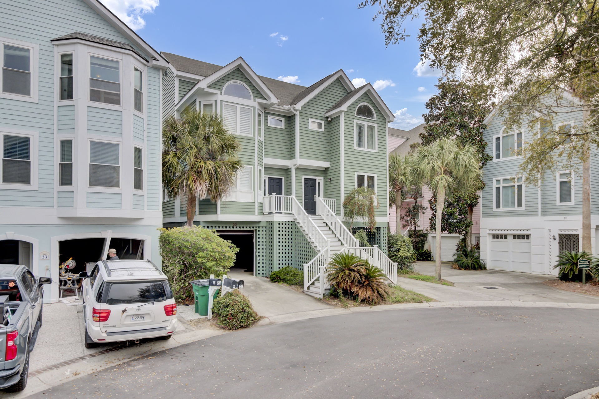 Charming coastal neighborhood with colorful beach houses and mature palm trees creates a welcoming atmosphere for your getaway.