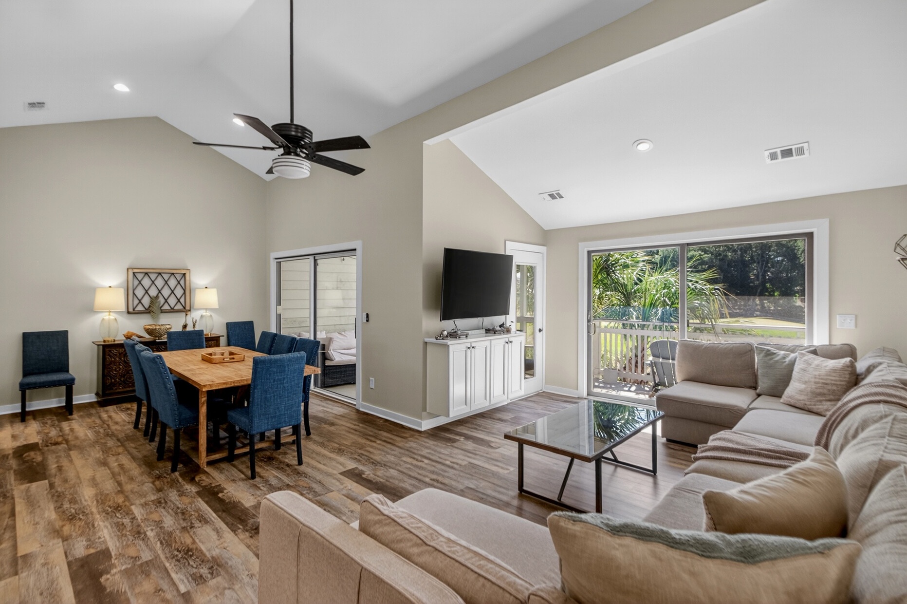 Step into this bright, open living space where vaulted ceilings and abundant natural light create an airy, welcoming atmosphere. Relax on plush seating, enjoy meals at the dining table, or step out to your private outdoor retreat.