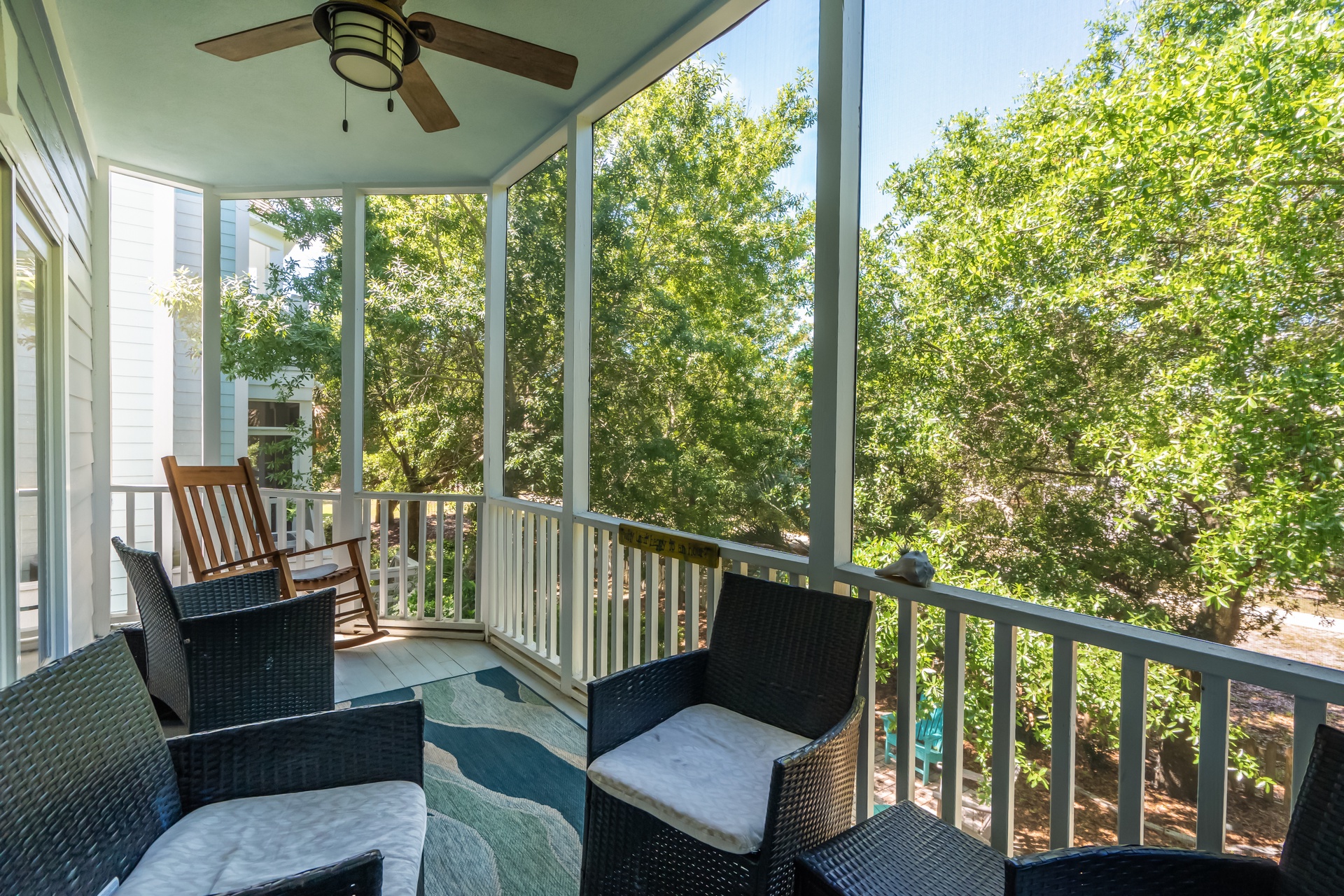 Relax in your screened porch with comfy seating and a gentle breeze from the ceiling fan as you gaze into lush, leafy treetops.