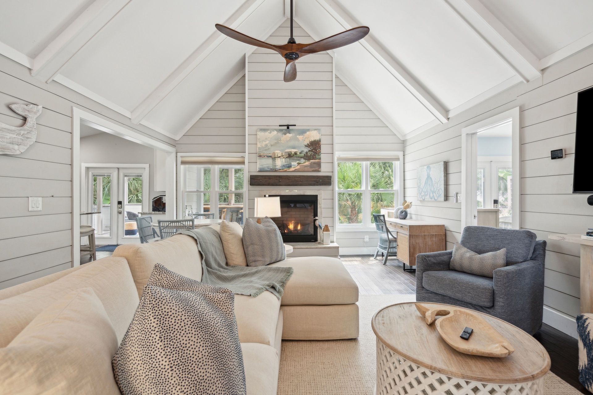 Sink into plush seating beneath soaring vaulted ceilings, where natural light pours through wall-to-wall windows and a cozy fireplace awaits to warm your evenings after exploring nearby adventures.