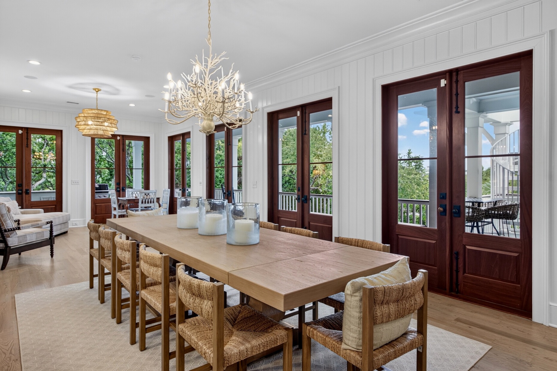 Step into this elegant dining space where a stunning chandelier illuminates your meals. Floor-to-ceiling French doors open to lush greenery and a peaceful balcony retreat.