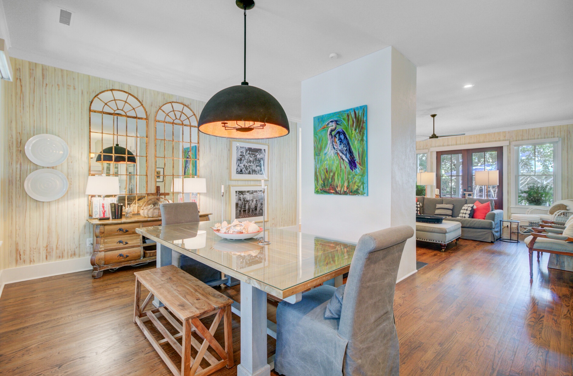 Gather around your spacious dining table, where warm pendant lighting and coastal artwork create the perfect setting for memorable meals together.