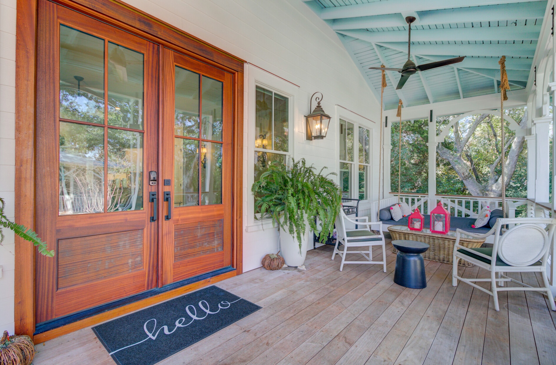 Welcome to your charming front porch where you can sip morning coffee surrounded by lush greenery and coastal charm.