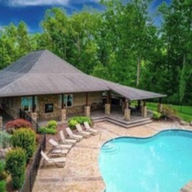 This stunning property features access to a seasonal community swimming pool surrounded by beautifully landscaped gardens and a spacious covered pavilion, all nestled within lush natural surroundings.