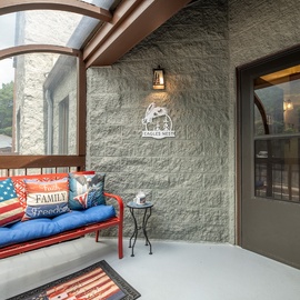 Eagle's Nest features a welcoming covered entryway with cozy seating, mountain views, and distinctive architectural details marking your arrival to this peaceful retreat.