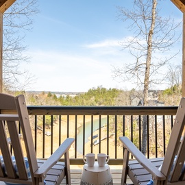 Sip your morning coffee on this peaceful covered balcony, where comfortable chairs invite you to unwind with stunning lake views.
