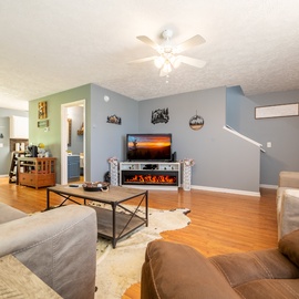 Settle into your cozy living room where warm wood floors and comfortable seating invite you to relax by the fireplace after a day of exploring.