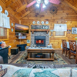 Cozy up by your crackling stone fireplace in this charming log cabin living room, complete with rustic charm and modern comforts.