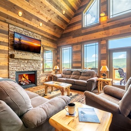 Sink into plush seating by the crackling fireplace and let your gaze drift through soaring windows to the mountain views beyond. This warm, inviting space is your retreat after a day of adventure.