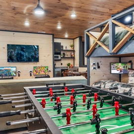 Challenge friends to foosball while cozy bunk beds await after your gaming sessions in this rustic entertainment haven.