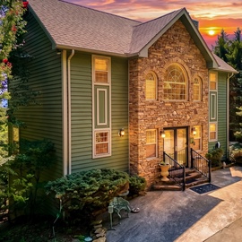 A stunning mountain retreat framed by towering pines and a breathtaking sunset, offering a warm welcome after a day of adventure.
