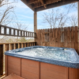 Soak in your private hot tub on the covered deck, surrounded by peaceful wooded views and complete privacy.
