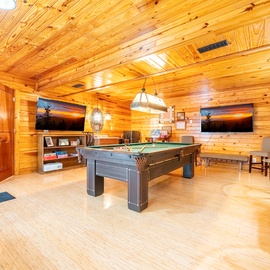 Your private game room awaits with pool table, entertainment center, and cozy wood-paneled warmth for endless fun.