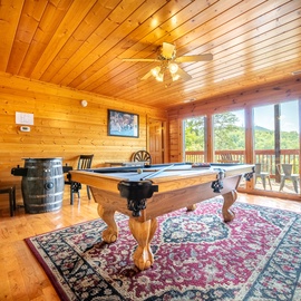 Step into your private game room featuring a full-size pool table and sweeping mountain views through expansive windows.