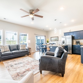 Relax in your stylish open-concept living space with modern kitchen, cozy seating, and warm wood floors.