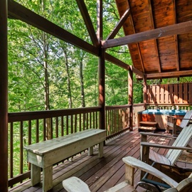 Unwind on your private deck surrounded by lush forest canopy, complete with hot tub and rustic seating for peaceful forest retreat moments.