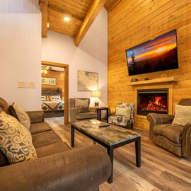 Picture yourself unwinding here after a day of adventure—plush seating, glowing fireplace, and a flat-screen TV create your perfect retreat.