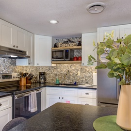 Your fully equipped kitchen features granite counters and modern appliances, perfect for preparing memorable meals during your stay.