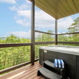 Soak beneath a covered terrace with sweeping mountain vistas stretching across lush forest. The deck offers a serene retreat where you can unwind in comfort surrounded by nature's beauty.