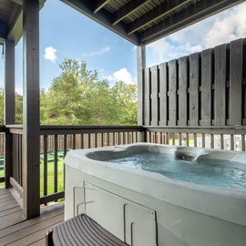 Soak away the day in your private hot tub with peaceful views of the surrounding trees.