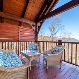 Unwind on your private covered balcony with comfortable wicker seating and stunning mountain views stretching to the horizon.