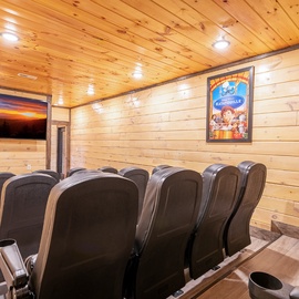 Sink into plush theater seats in your private cinema room, where rustic wood meets modern comfort for unforgettable movie nights.