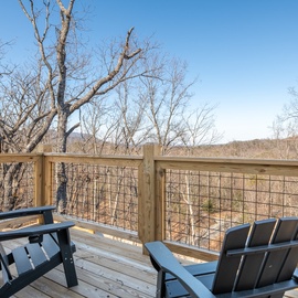 Relax in comfortable deck chairs while soaking up peaceful forest views from your private balcony retreat.