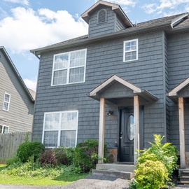 A charming duplex exterior with well-maintained landscaping and welcoming covered entryways in a quiet residential neighborhood.