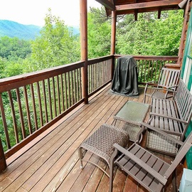 Your private deck offers the perfect spot to unwind, with cozy seating and a grill ready for a relaxing evening surrounded by lush forest and mountain vistas.