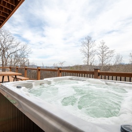 Soak in your private hot tub while taking in sweeping mountain views from this spacious deck.