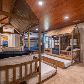Your family's dream adventure awaits in this charming bunk room, where rustic cabin-style beds create a cozy camp-like atmosphere. Perfect for kids and groups to bond and share stories under warm wood-paneled ceilings.