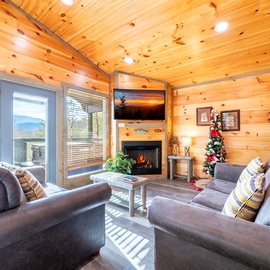 Warm up by your crackling fireplace while enjoying mountain views through expansive windows in this cozy cabin living room.