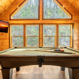 Challenge friends to pool in your private game room, surrounded by forest views and warm cabin charm.