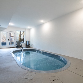 Dive into your private indoor oasis with this stunning heated pool, complete with poolside loungers for ultimate relaxation year-round.