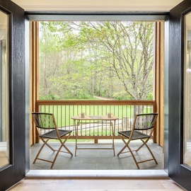 Step onto your private balcony, where morning coffee and peaceful moments await among the trees.