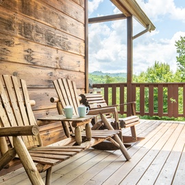 Unwind in handcrafted wooden chairs on your private deck overlooking lush mountain scenery—a peaceful retreat where morning coffee tastes even better with nature as your backdrop.