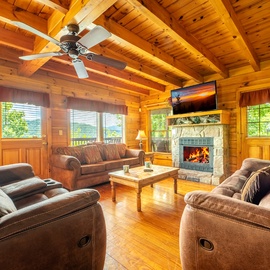Sink into plush recliners beneath vaulted wood ceilings, where a crackling fireplace and mountain views create your perfect retreat for cozy evenings together.