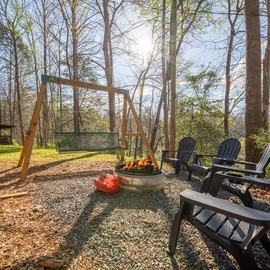Gather around your private fire pit for evening stories while kids play on the swing set in this peaceful wooded retreat.
