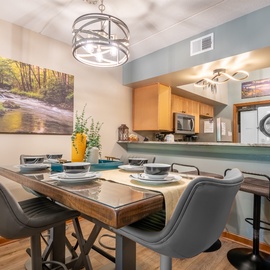Gather around the stylish dining table for memorable meals together, with a fully equipped kitchen just steps away for your convenience.