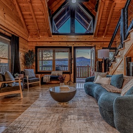 Cozy up in this stunning wood-beamed living room where mountain views frame your perfect retreat through picture windows.