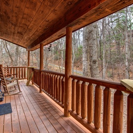 Step onto your private wooden deck and breathe in the fresh forest air while rocking gently in rustic chairs surrounded by nature.