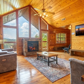 Sink into plush seating as natural light pours through soaring windows and the glow of your fireplace warms the rich wood around you.
