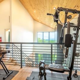 Work out with a view in your private fitness area featuring modern equipment beneath warm wood-vaulted ceilings and natural light that makes staying active feel effortless.