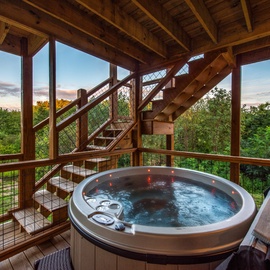 Soak away the day in your hot tub under a vaulted wood-beamed ceiling, with lush greenery and peaceful skies surrounding you on all sides.