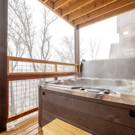Soak in your private hot tub while trees create a peaceful backdrop—pure relaxation awaits you.