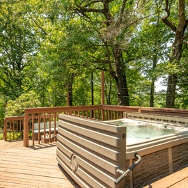 Soak in the hot tub on your private deck, surrounded by towering trees and dappled sunlight—pure forest-wrapped relaxation.